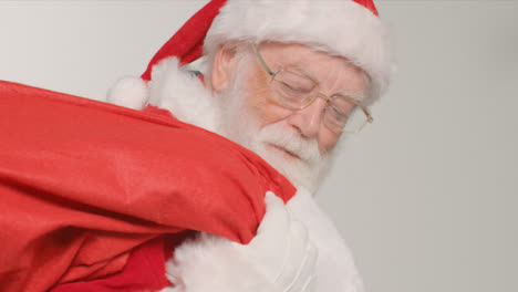 Close-Up-Shot-of-Santa-Walking-Into-and-Out-of-Frame-Holding-Sack-of-Presents